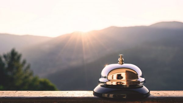 Silver vintage bell on village reception desk in the morning sunrise (iStock/FTiare)
