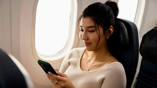 Air Canada customer using their mobile phone inflight (image from https://media.aircanada.com/)